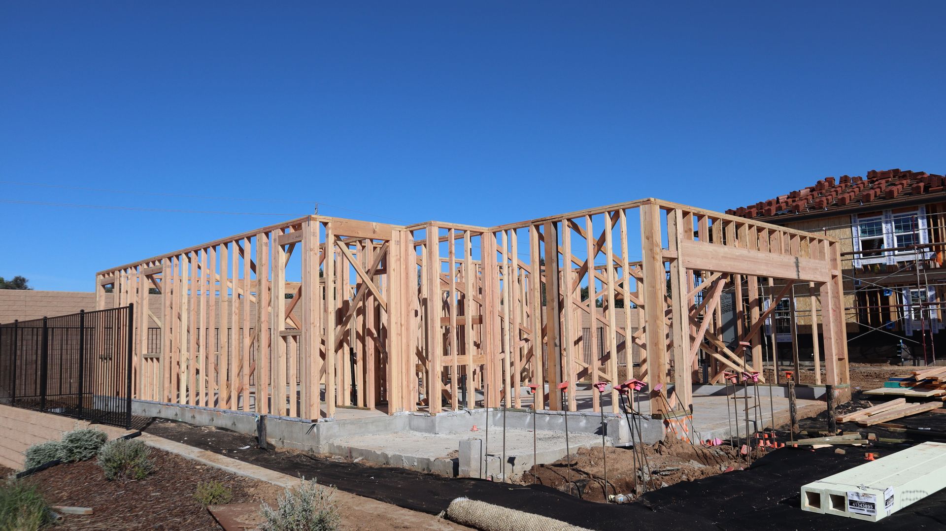Wood framing of a house under construction in a sunny California subdivision.